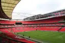 Inside Wembley Stadium, with tiers of red seats around an empty pitch