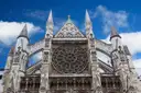 The rose window and pinnacles of Westminster Abbey against a blue sky