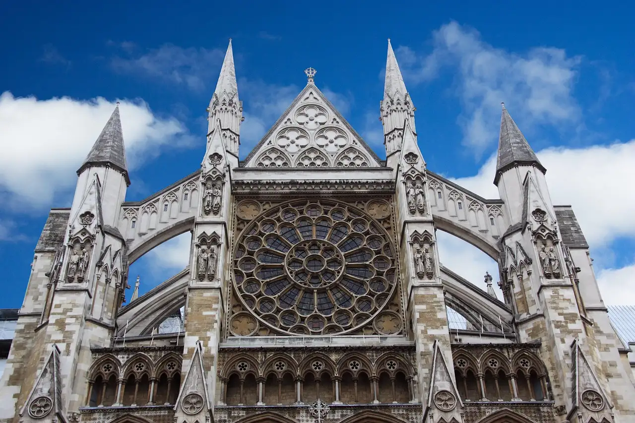 The rose window and pinnacles of Westminster Abbey against a blue sky