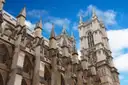 The towers of Westminster Abbey under a blue sky with white clouds