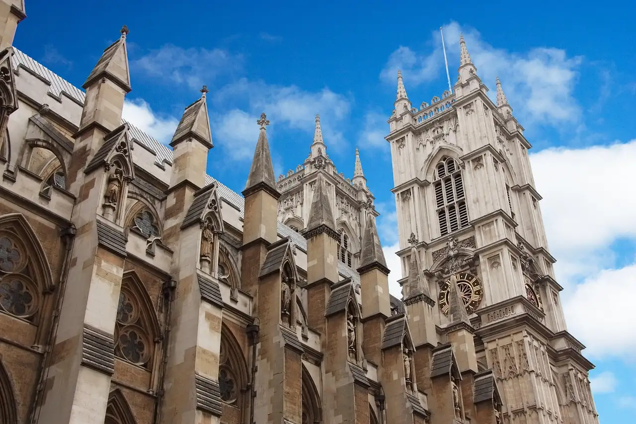The towers of Westminster Abbey under a blue sky with white clouds