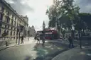 A Westminster street with Big Ben in the distance and a red double-decker bus crossing