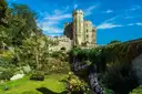 Windsor Castle tower above a green garden with flowers