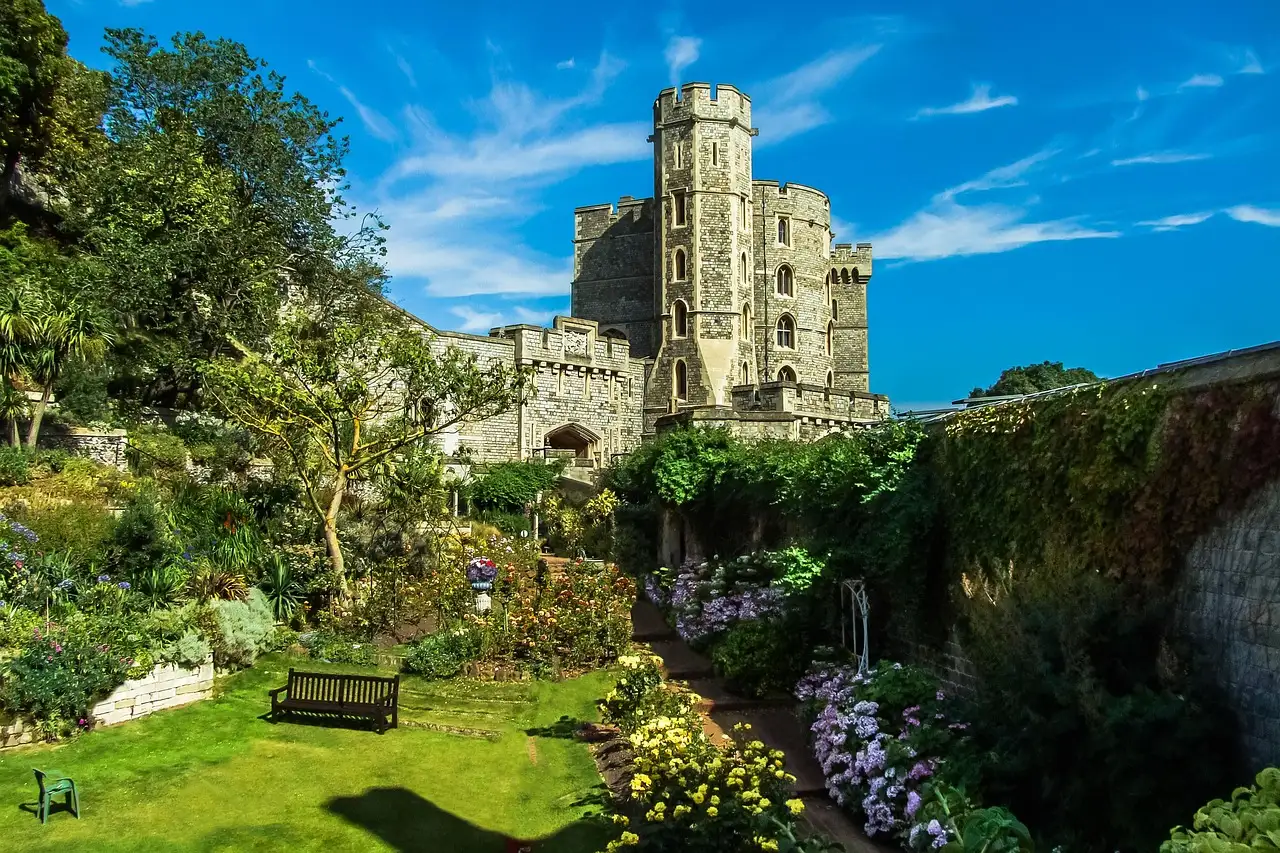 Windsor Castle tower above a green garden with flowers